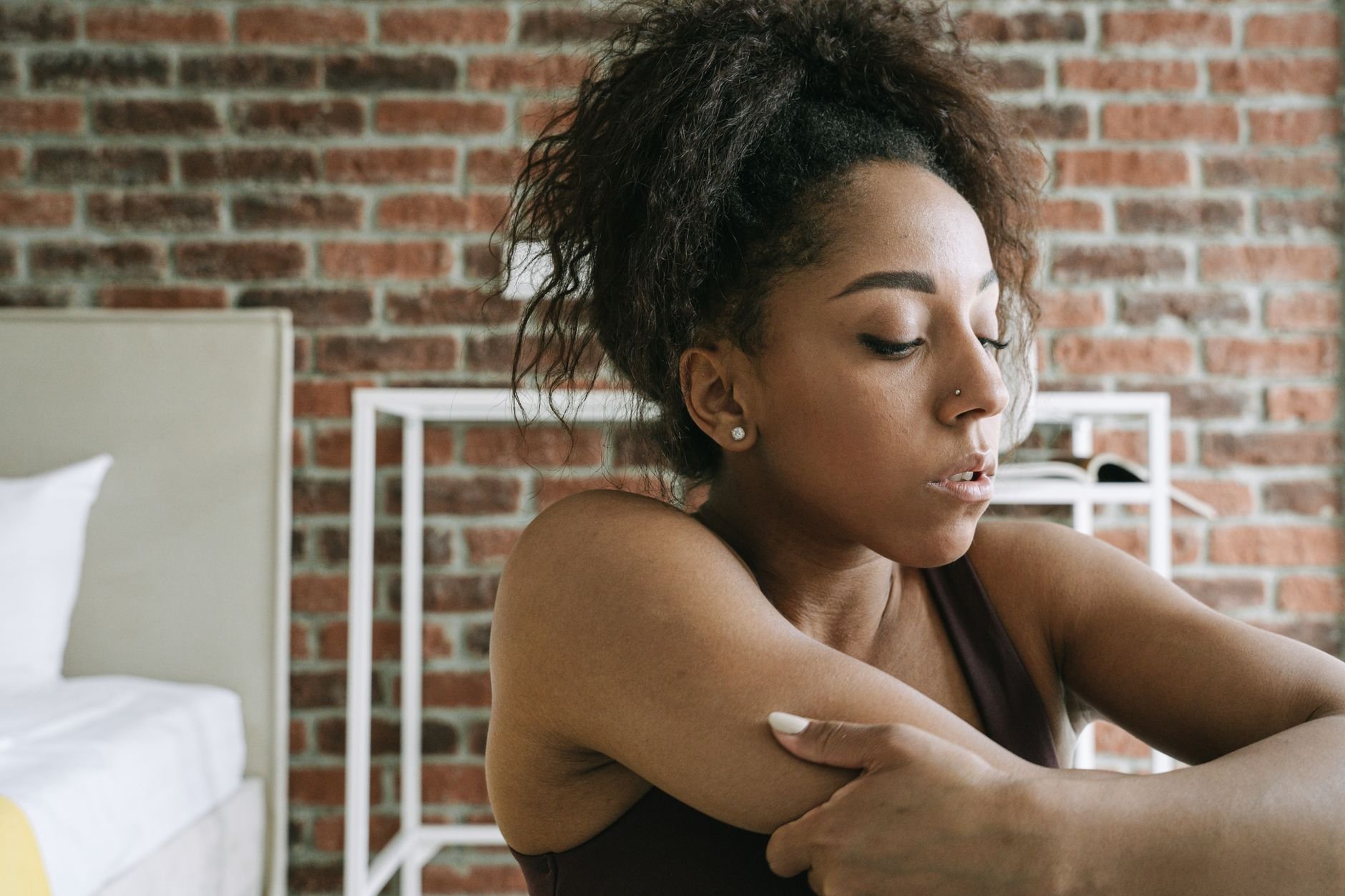 African American woman doing yoga and stretching at home, emphasizing health and relaxation.